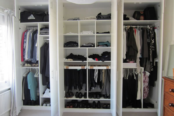 Fitted wardrobe with doors open to show hanging and shelving space